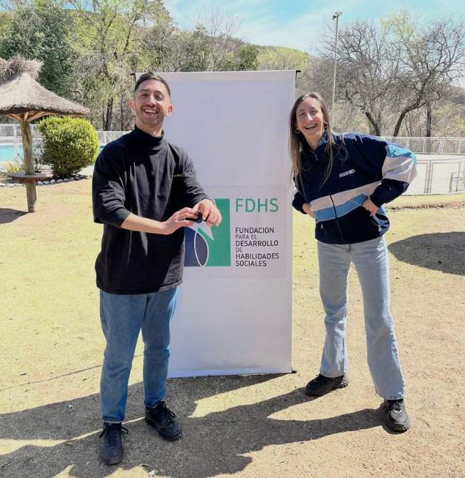 Dos integrantes de la fundación junto al banner de FdHS